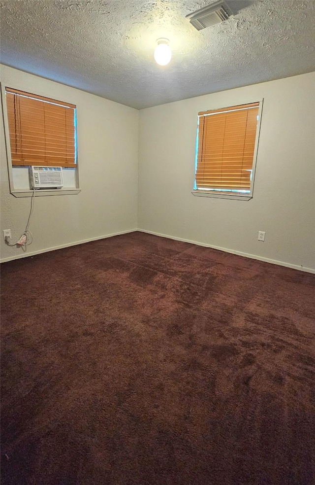 carpeted spare room featuring a textured ceiling and cooling unit