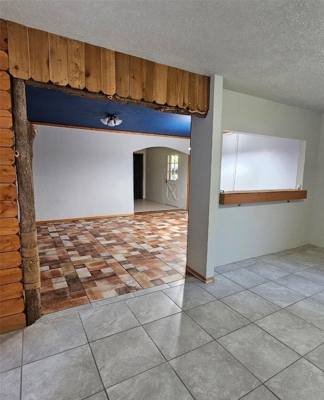 spare room with tile patterned flooring and a textured ceiling