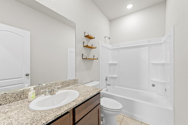 full bathroom featuring toilet, vanity, tile patterned floors,  shower combination, and a textured ceiling