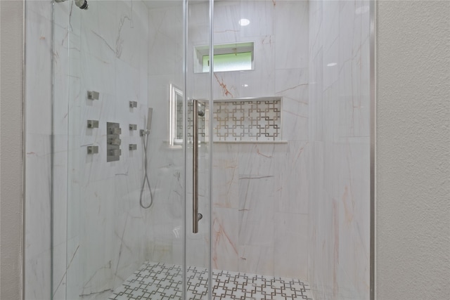 bathroom with a shower with door