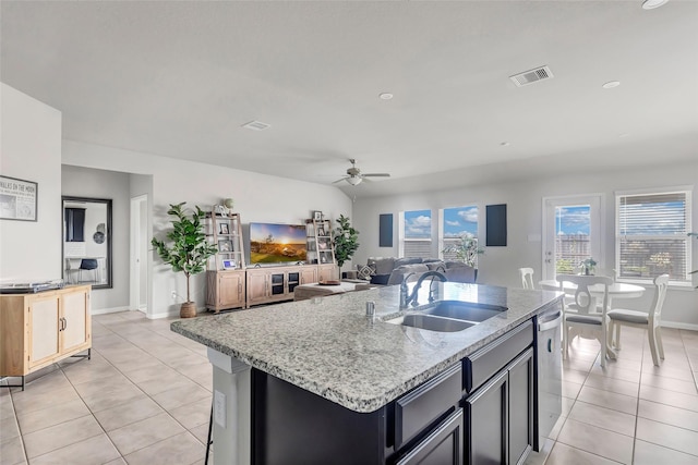 kitchen with light tile patterned flooring, sink, a kitchen island with sink, and ceiling fan