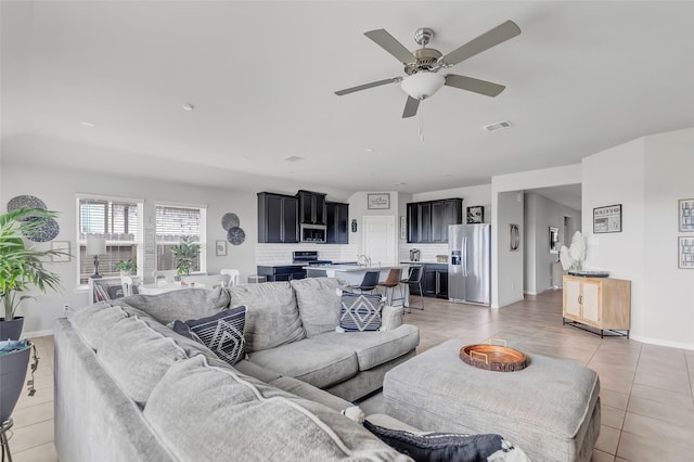 tiled living room with ceiling fan and sink