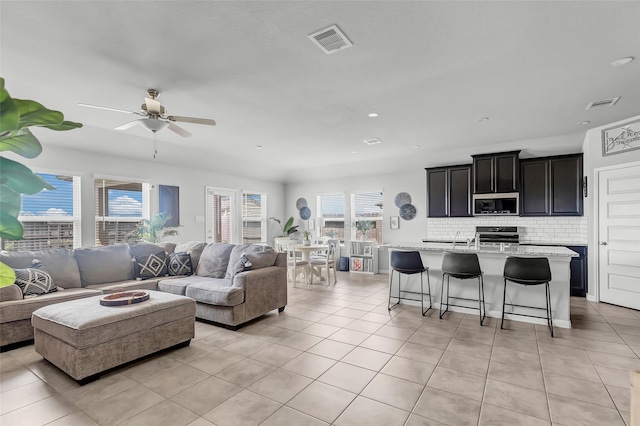 tiled living room with ceiling fan and a healthy amount of sunlight