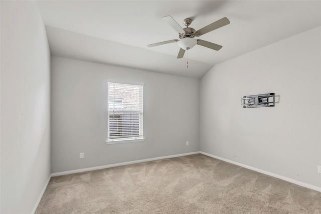 spare room with ceiling fan, light colored carpet, and lofted ceiling