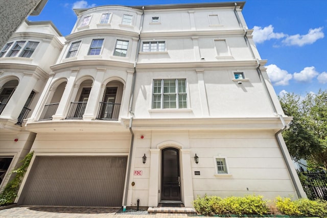 view of front of property featuring a balcony and a garage