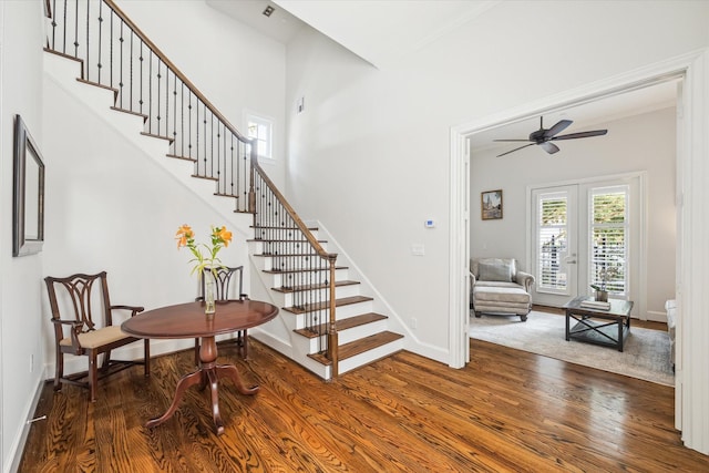 stairs with french doors, ceiling fan, and hardwood / wood-style floors