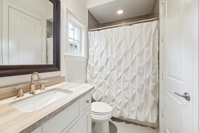 bathroom with toilet, vanity, and walk in shower