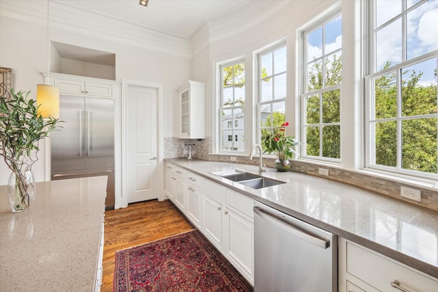 kitchen featuring white cabinets, appliances with stainless steel finishes, sink, and light stone counters