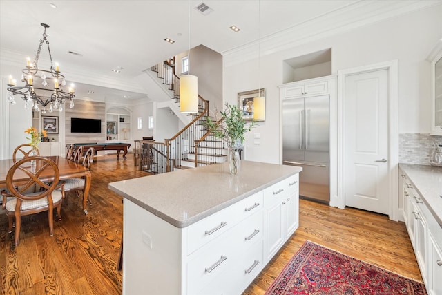 kitchen featuring built in fridge, white cabinetry, billiards, and a kitchen island