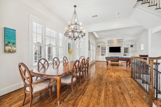 dining space with hardwood / wood-style floors, built in features, ornamental molding, billiards, and a chandelier