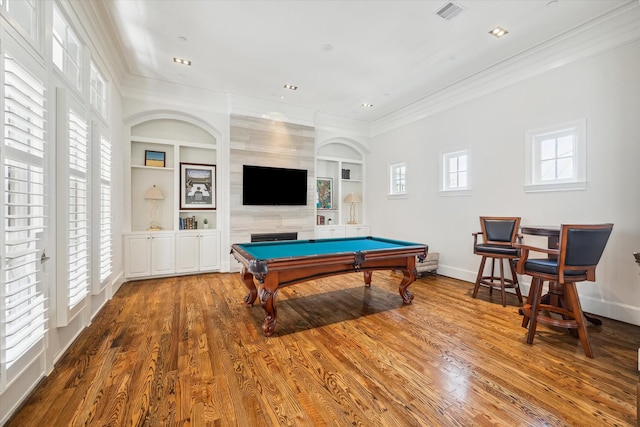 recreation room with a fireplace, crown molding, hardwood / wood-style flooring, built in shelves, and pool table