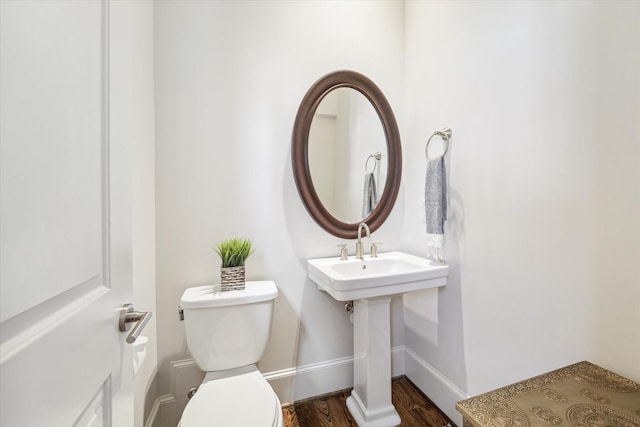 bathroom with toilet, hardwood / wood-style flooring, and sink