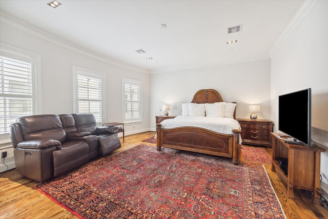 bedroom with ornamental molding and hardwood / wood-style floors