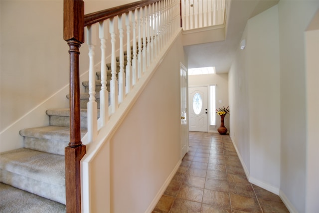 stairs with tile flooring and a towering ceiling