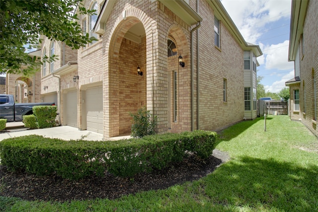 view of home's exterior featuring a garage and a lawn