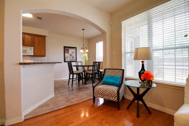 sitting room with a notable chandelier and light tile floors