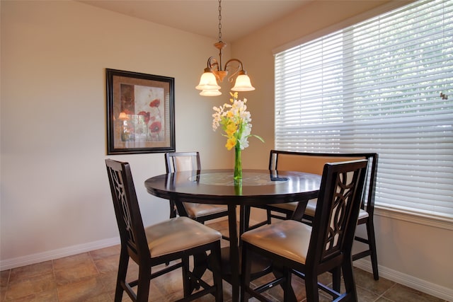 tiled dining area featuring a chandelier