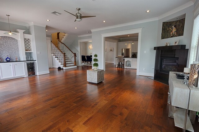 living room with ornamental molding, ceiling fan, wine cooler, and dark hardwood / wood-style flooring