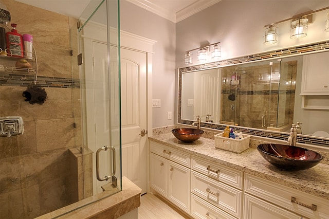 bathroom with walk in shower, ornamental molding, large vanity, and double sink