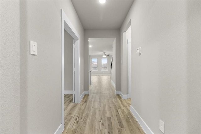 corridor with light hardwood / wood-style floors