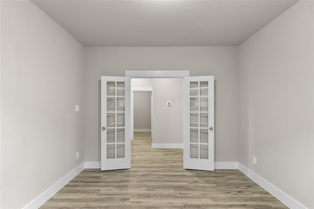 empty room featuring french doors and light hardwood / wood-style floors