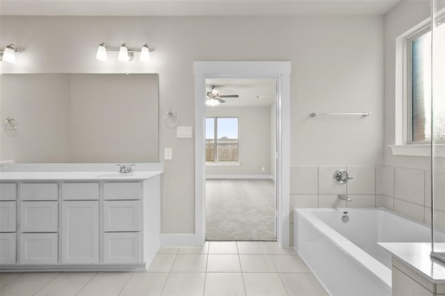 bathroom featuring tile patterned floors, vanity, a bathtub, and ceiling fan