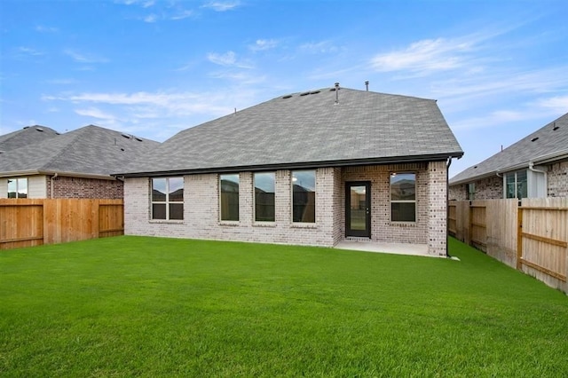 rear view of house featuring a yard and a patio