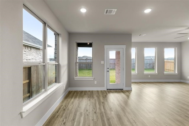 doorway to outside with recessed lighting, wood finished floors, visible vents, and baseboards
