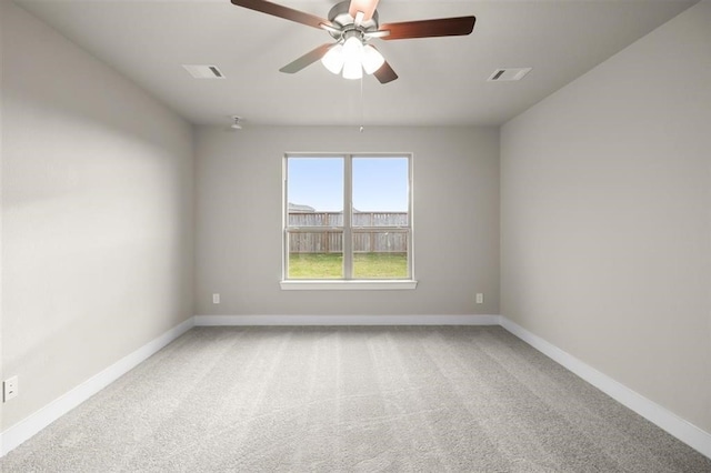 carpeted empty room with visible vents, baseboards, and ceiling fan