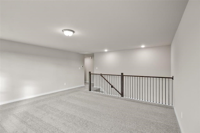 carpeted empty room with baseboards and recessed lighting