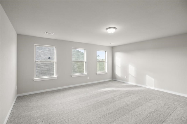 unfurnished room with visible vents, baseboards, and carpet