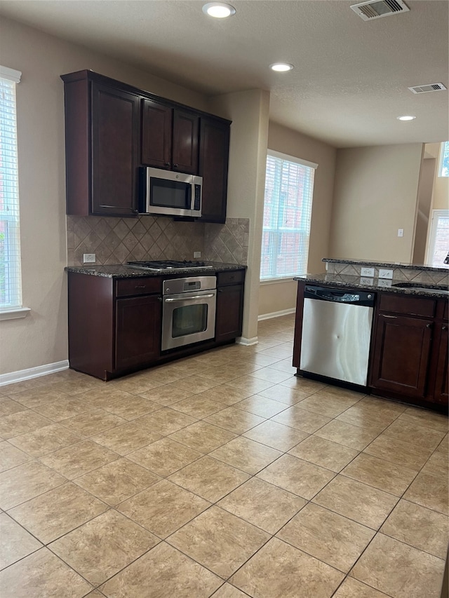 kitchen featuring sink, appliances with stainless steel finishes, backsplash, and plenty of natural light