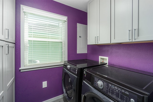 laundry room featuring cabinets, washing machine and dryer, and electric panel