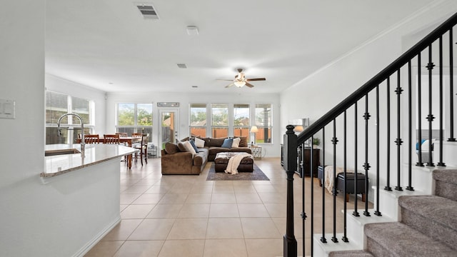 living room with ceiling fan, sink, light tile patterned floors, and ornamental molding