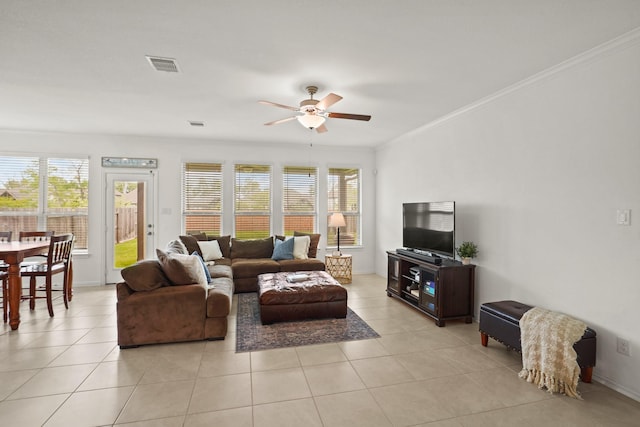 living room with ceiling fan, light tile patterned flooring, visible vents, baseboards, and crown molding