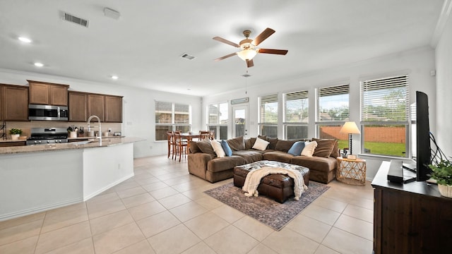 tiled living room featuring ceiling fan and ornamental molding