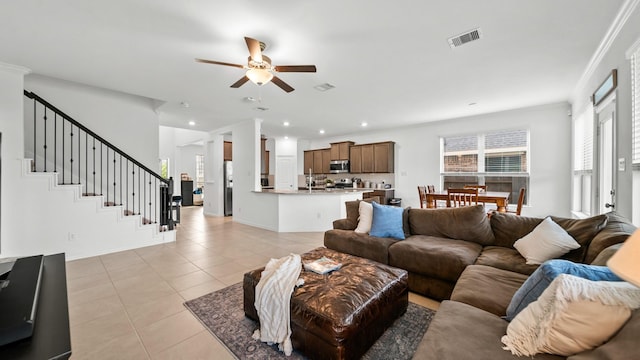 living room with ceiling fan, light tile patterned floors, and ornamental molding