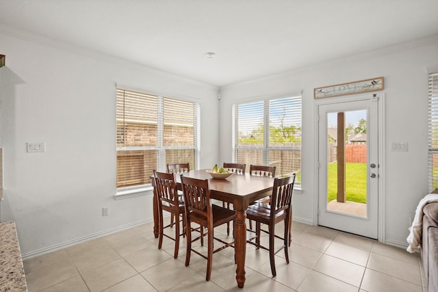 dining room with light tile patterned floors, baseboards, and ornamental molding