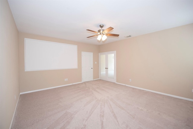 unfurnished room featuring light carpet, french doors, and ceiling fan