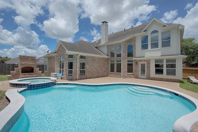 view of swimming pool with a patio area, an in ground hot tub, and an outdoor fireplace