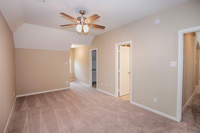 interior space featuring ceiling fan, light carpet, and vaulted ceiling