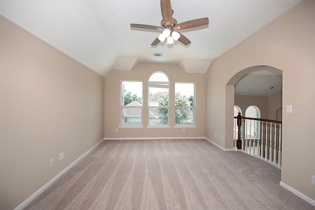 unfurnished room featuring light carpet, vaulted ceiling, and ceiling fan