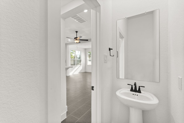 bathroom with a sink, visible vents, a ceiling fan, and a textured wall