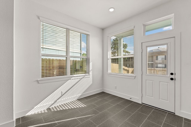 doorway to outside with dark tile patterned flooring, baseboards, and recessed lighting
