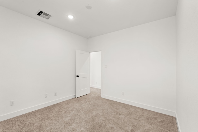 unfurnished room with visible vents, baseboards, and light colored carpet