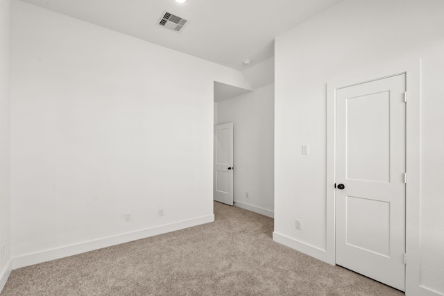 unfurnished bedroom featuring visible vents, light colored carpet, and baseboards