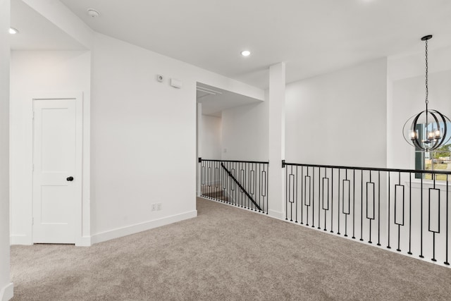 carpeted empty room with baseboards, recessed lighting, and an inviting chandelier