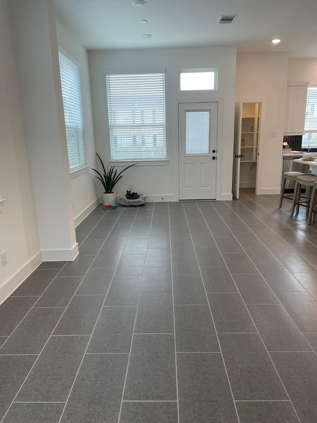 entryway featuring visible vents, baseboards, recessed lighting, and dark tile patterned flooring