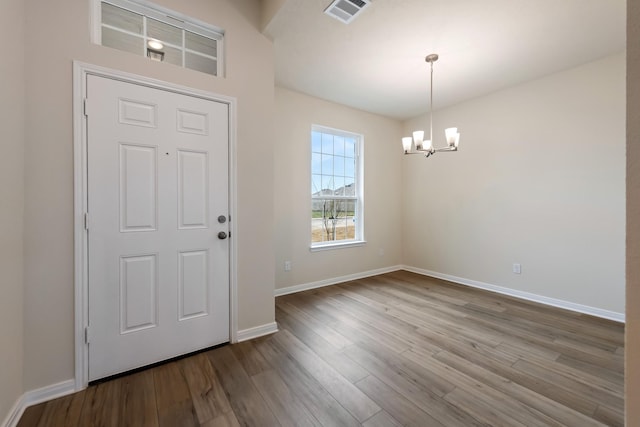 foyer featuring wood-type flooring and a chandelier