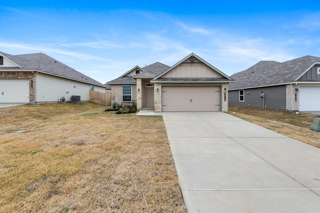 view of front of property with a garage, cooling unit, and a front lawn